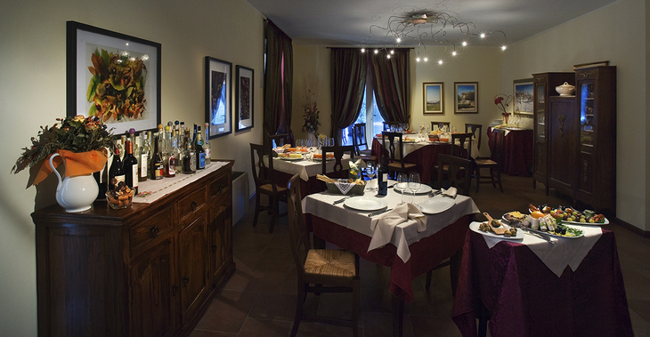 Esszimmer in einem italienischen Agriturismo, elegant eingedeckt mit Wein und Speisen.