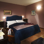 Doppelzimmer mit blauen Möbeln und lila Wänden im Agriturismo Mongalletto.
