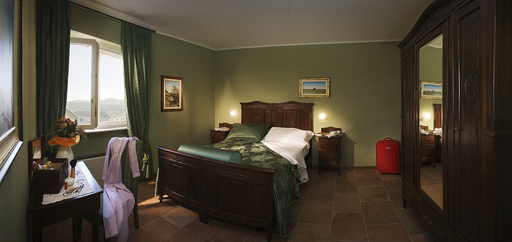 Gemütliches Schlafzimmer in einem Agriturismo mit grüner Einrichtung und Holzmöbeln.