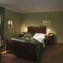 Gemütliches Schlafzimmer in einem Agriturismo mit grüner Einrichtung und Holzmöbeln.