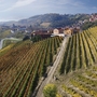 Blick auf Weinberge und Hügel mit Dorf im Hintergrund bei Mongalletto, Castellinaldo.