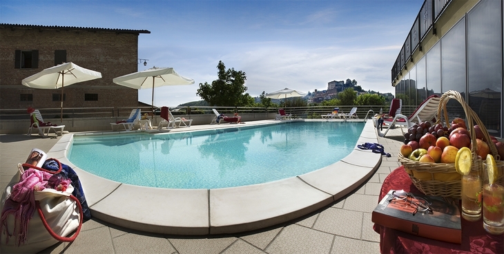Pool mit Liegestühlen und Obstkorb im Agriturismo Mongalletto in Italien.