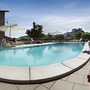Pool mit Liegestühlen und Obstkorb im Agriturismo Mongalletto in Italien.