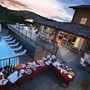 Terrasse mit Pool und gedeckten Tischen bei Abenddämmerung in Italien.
