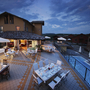 Terrasse eines Agriturismo mit gedeckten Tischen bei Abenddämmerung.