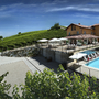 Agriturismo mit Pool und Sonnenschirmen, umgeben von Weinbergen und Natur.