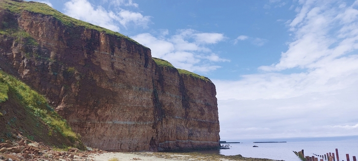 Klippenlandschaft auf Helgoland unter blauem Himmel.