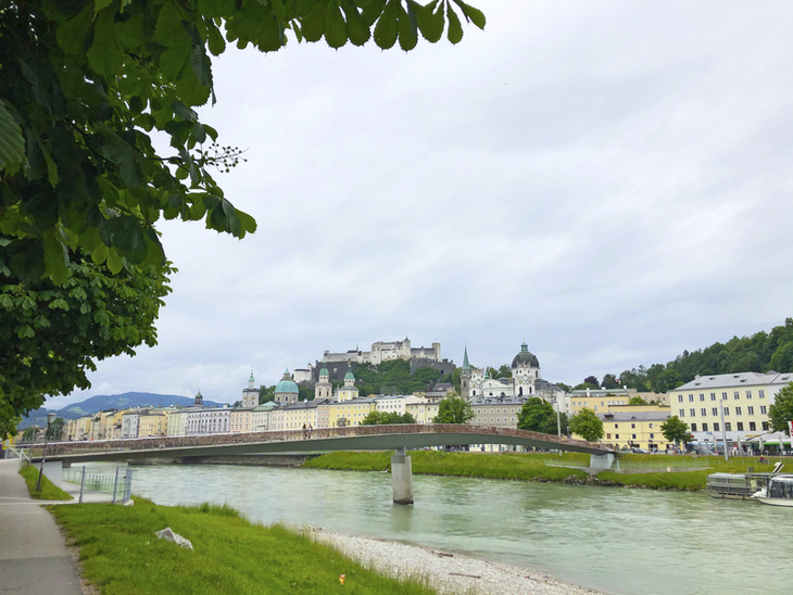 Blick auf die Altstadt von Salzburg, Fluss und Burg im Hintergrund.