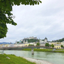Blick auf die Altstadt von Salzburg, Fluss und Burg im Hintergrund.