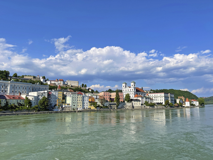 Blick auf die Stadt Passau am Fluss bei klarem Himmel.