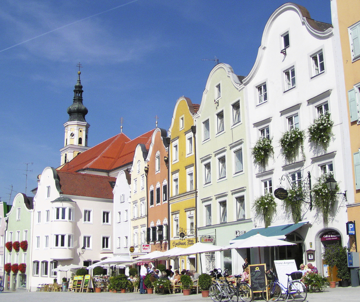 Historische Häuserreihe in Schärding mit Café und Fahrrädern im Vordergrund.