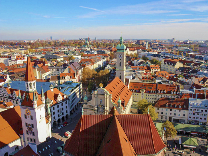 Blick auf München mit historischen Gebäuden und Kirchtürmen bei klarem Himmel.
