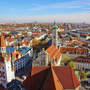 Blick auf München mit historischen Gebäuden und Kirchtürmen bei klarem Himmel.
