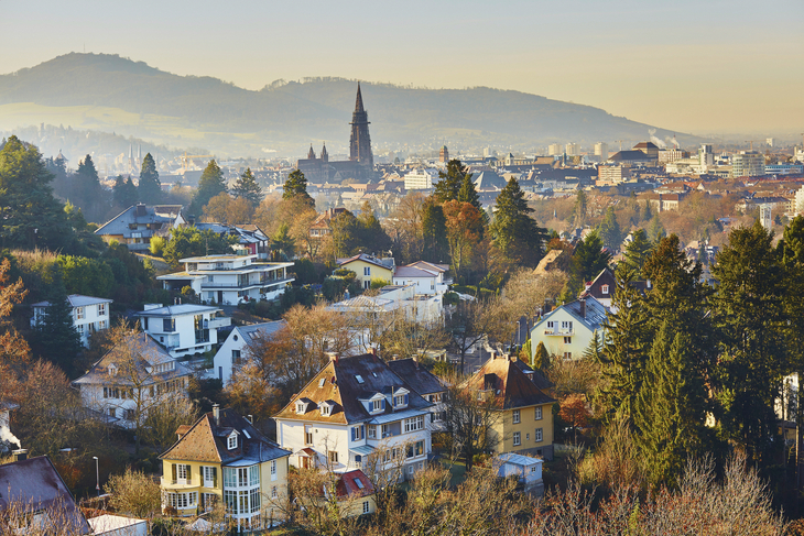 Blick auf Freiburg im Winter mit Häusern und dem charakteristischen Münster im Hintergrund.