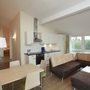 Moderne Küche und Wohnbereich mit Ecksofa und Esstisch.