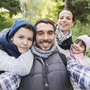 Eine Familie macht ein Selfie im Wald.