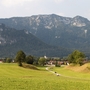 Dorf Inzell vor Alpenkulisse mit grünen Wiesen und bewaldeten Bergen.