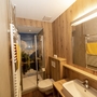 Modernes Badezimmer in einem Ferienhaus mit Dusche und Holzverkleidung.