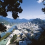 Panorama von Salzburg mit Altstadt und Festung Hohensalzburg, umgeben von Bergen.