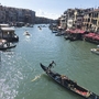 Eine Gondel fährt auf einem Kanal in Venedig bei sonnigem Wetter.