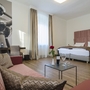 Hotelzimmer mit Doppelbett, Sofa, Tisch und Dekorationen.
