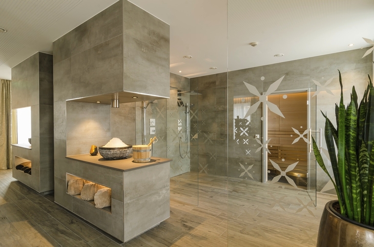Moderner Wellnessbereich mit Sauna und dekorativen Elementen in neutralen Farben.