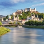 Blick auf die Festung Hohensalzburg in Salzburg, im Vordergrund die Salzach.