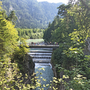 Brücke über einen Wasserfall in einer bewaldeten Berglandschaft auf dem Bayerischen Jakobsweg.