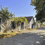Gepflasterter Weg durch historische Kellergasse mit Steinmauern und Holzfenstern