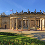 Historisches Gebäude mit Säulen und italienischer Flagge im Hintergrund.