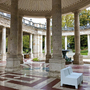 Säulenhalle der Terme Tettuccio mit Sitzgelegenheiten und Gartenansicht.