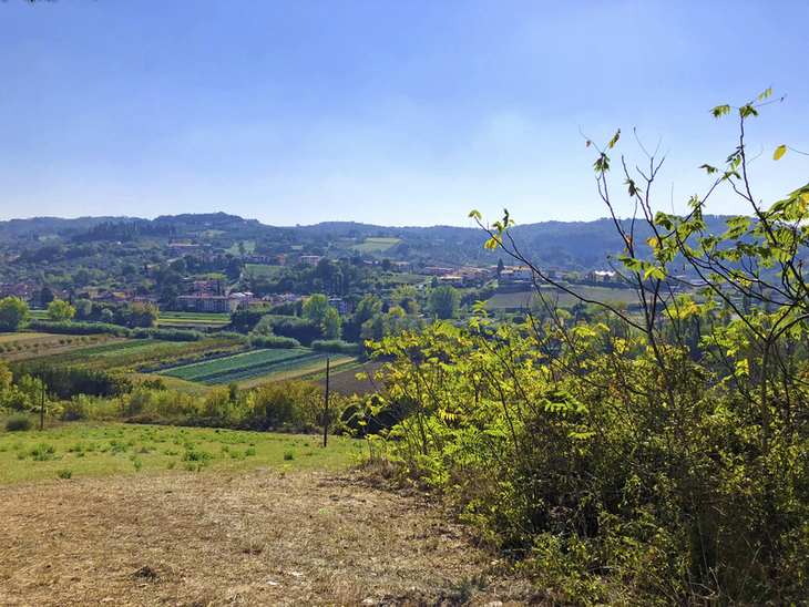 Landschaftsausblick bei Pistoia mit Feldern und Hügeln unter klarem Himmel