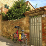 Fahrrad vor steinernem Haus und Garten, sonniger Tag in Vinci, Italien.