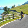 Radfahrer auf einem malerischen Weg am Reschensee mit Bergen im Hintergrund