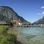 See mit Kirche St. Bartholomä und Bergen im Hintergrund bei sonnigem Wetter.