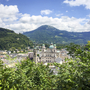 Aussicht auf Salzburg mit grüner Landschaft und Bergen im Hintergrund
