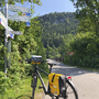 Fahrrad am Wegweiser auf dem Lechradweg in grüner Berglandschaft.