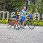 Zwei Personen schieben Fahrräder an der Passerpromenade in Meran.