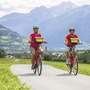 Radfahrer auf Flussradweg in Südtirol mit Bergen im Hintergrund
