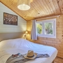 Holzvertäfeltes Schlafzimmer mit Doppelbett und Fenster.