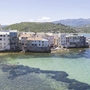 Küstenstadt mit Gebäuden am Meer und Bergen im Hintergrund in Saint-Florent, Korsika.
