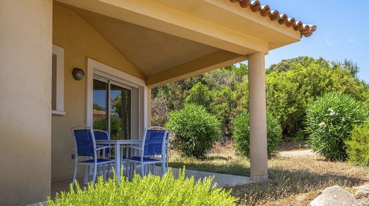 Terrasse eines Ferienhauses mit Tisch und Gartenblick