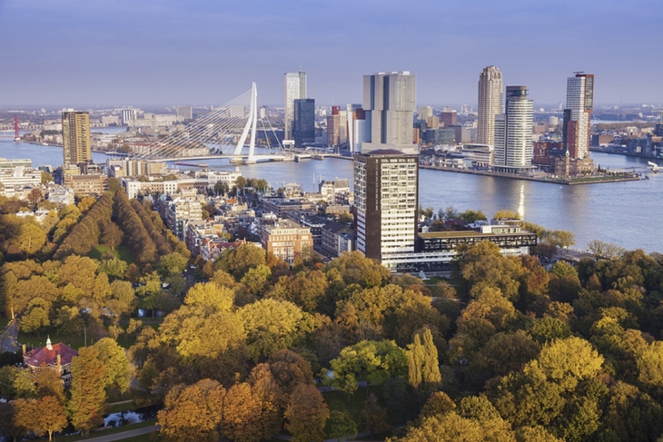 Städtische Skyline von Rotterdam mit Fluss und Brücke im Herbst.