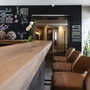 Lobby des Hotels Imhof in Gemünden mit Holztheke und Pflanzen.