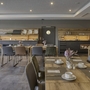 Hotelrestaurant mit gedeckten Tischen und moderner Einrichtung.