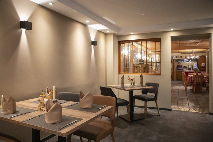 Moderner Essbereich in einem Restaurant mit gedeckten Tischen und stilvoller Beleuchtung.