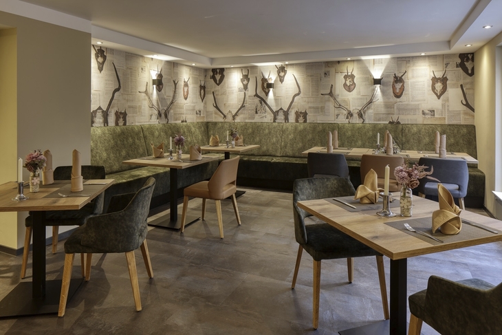 Restaurantbereich mit Wanddeko aus Jagdtrophäen und stilvollen Tischgedecken.