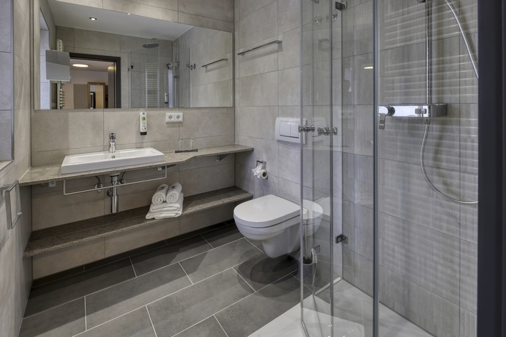 Modernes Badezimmer mit Glasdusche und Waschbecken im Hotel Imhof, Gemünden.