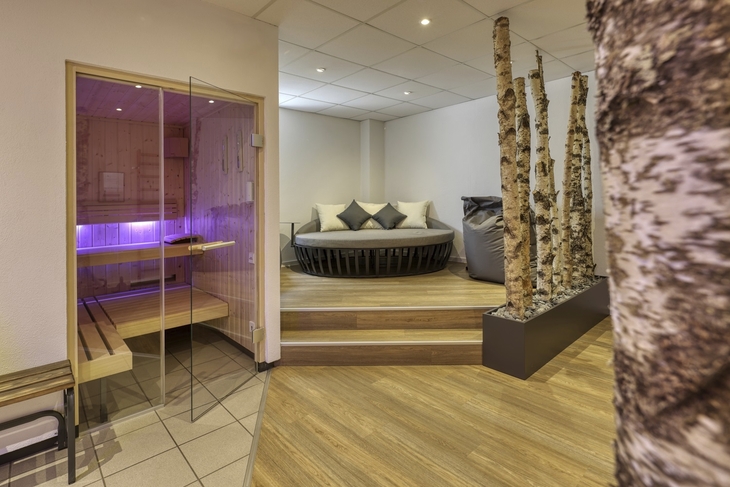 Wellnessbereich mit Sauna, Ruheliege und Birkenstämmen im Hotel Imhof, Gemünden.