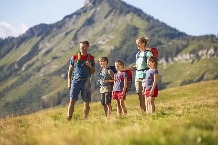 Familie beim Wandern auf einer Alm mit Bergblick im Salzkammergut